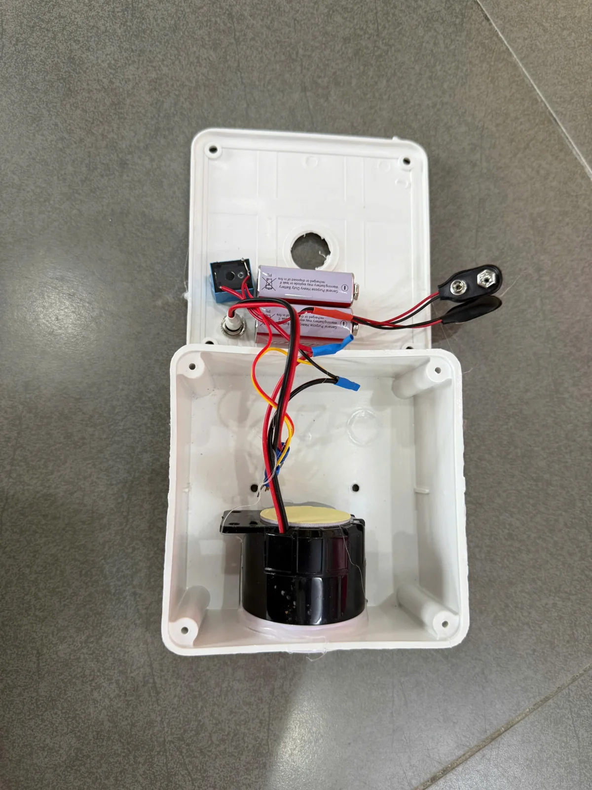 Bên trong đế đầu báo độc lập: còi báo và 2 pin 9V Bên trong đế đầu báo độc lập: còi báo và 2 pin 9V