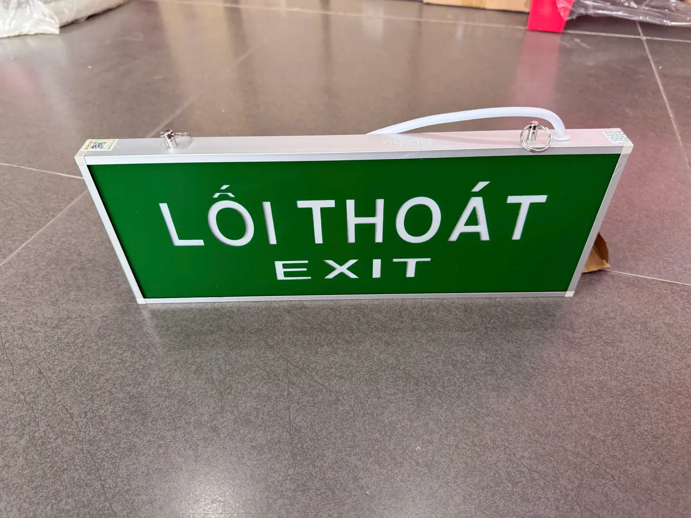 Đèn Exit Lilang 2 mặt không hướng + Tem kiểm định Đèn exit Lilang LỐI THOÁT EXIT không chỉ hướng khung nhôm – ảnh thực tế tại Thietbi114