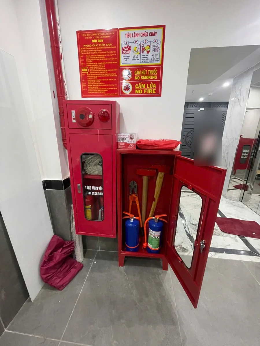Tủ đựng phương tiện mở cửa có kìm cộng lực, búa, rìu và hai bình chữa cháy, trên nóc là hộp mặt nạ phòng độc, cạnh hộp chữa cháy và bảng nội quy tiêu lệnh